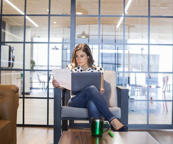 Woman sitting in office armchair checking documents