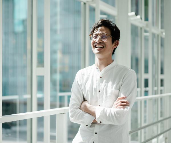 Young smiling businessman in a hallway with glass windows