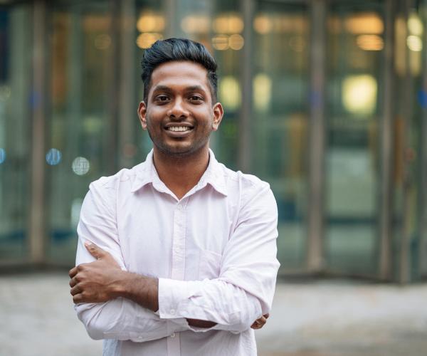 Young businessman smiling with arms crossed. 