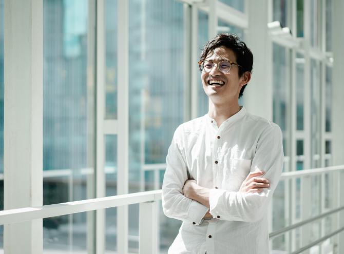 Young smiling businessman in a hallway with glass windows