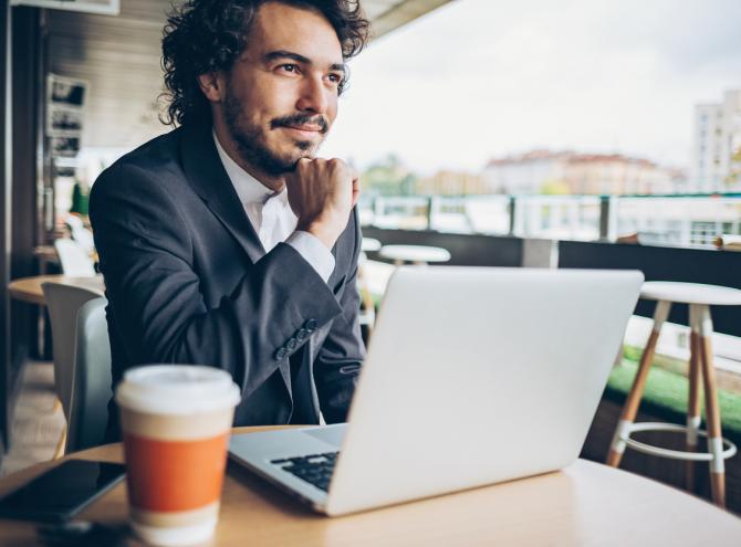 Man sitting in cafe with laptop